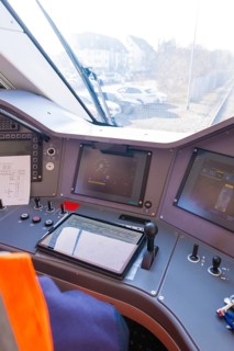 Train driver's cab with modern control monitors and control elements, test run on the new