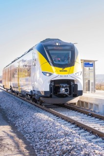 Modern yellow-black train on a sunny platform, test run on the new Hermann-Hesse railway with