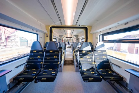Modern train design with yellow accents and bright window light, test run on the new Hermann-Hesse
