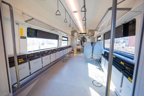 Modern train compartment with bright colors and comfortable seats, large windows and handles for