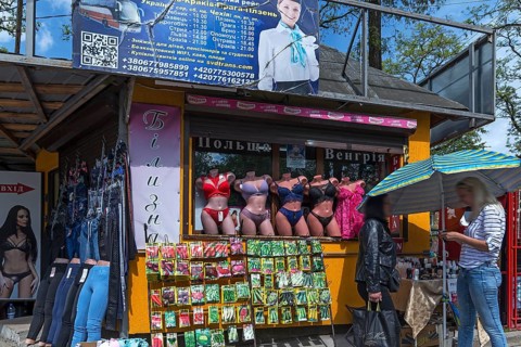 Sales stand with mannequins with corsetry, in front of a stand with bags of vegetable seeds,