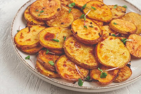 Crispy potato slices, with parmesan cheese and spices, fried in the oven, homemade, no people