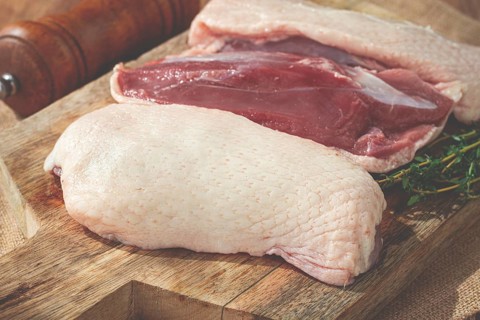 Fresh raw duck breast, on a wooden chopping board, top view, no people