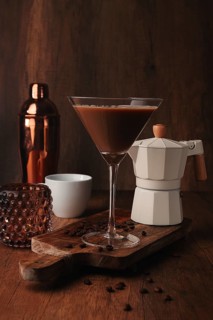 Espresso martini cocktail, alcoholic drink, shaker and geyser coffee maker, on a wooden background