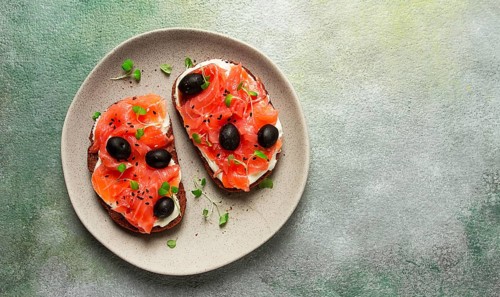 Sandwiches with red fish, cream cheese, olives and microgreens, breakfast