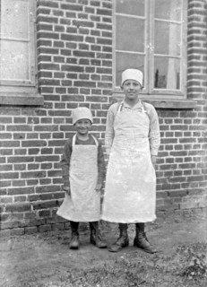 Children of a baker family pose with aprons and headgear for the photo, ca. 1920-1930, retro,