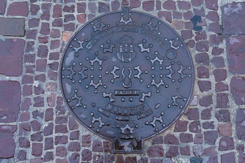 Manhole cover with the coat of arms of the city of Krakow, Krakow, Poland