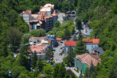 Overview of the city nestled in a green, wooded area with various buildings, Borjomi, Borjomi