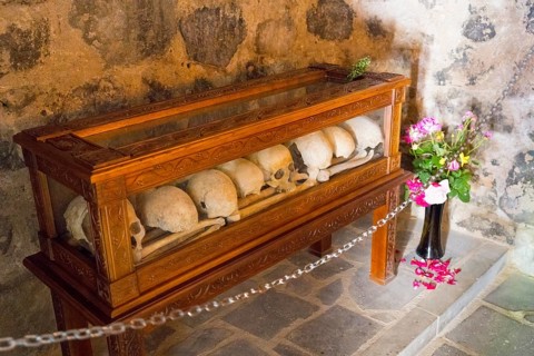 Bones in a wooden display case with flowers in a historical context, Chitakhevi Church of St.