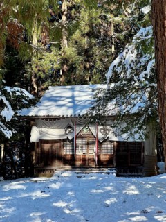 A shrine in the forest covered with snow surrounded by tall trees and wintry atmosphere, winter,