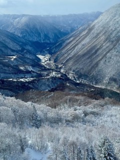 Snowy mountains and a valley with a river. The cold winter sky creates a calm atmosphere, winter,