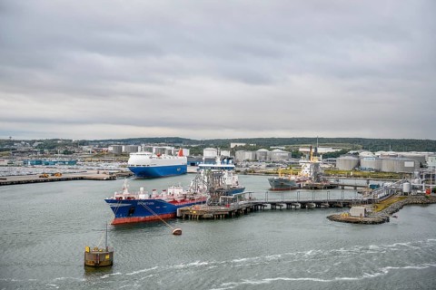 Industrial port with tanks and ships on calm water under a grey sky, Gothenburg, Västra Götalands