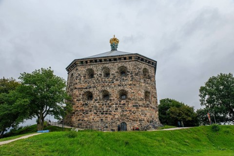 Massive historic stone fortress Skansen Kronan with a decorative crown on a hill surrounded by