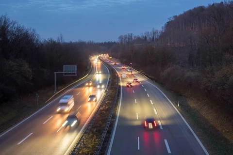 Night view of a motorway trip in the dark, surrounded by forest and vehicle lights, near Stuttgart,