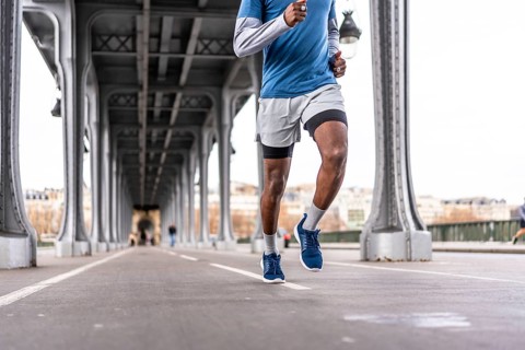 Young man running a daily urban workout across bir hakeim bridge in paris, showcasing fitness,