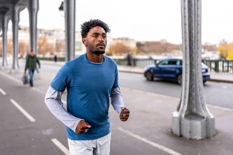 Young black man training on bir hakeim bridge in paris, jogging along the seine during a morning