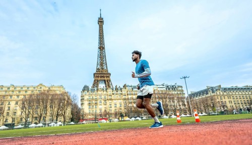 Male athlete intensely running on a red synthetic track, training and exercising with the iconic