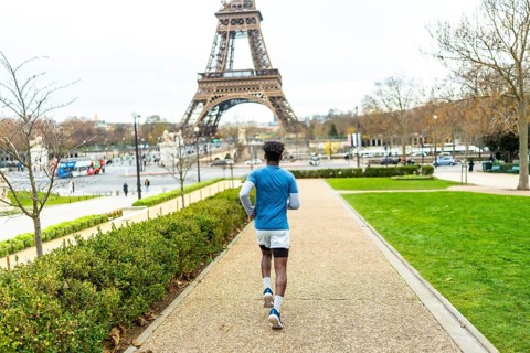 Young man exercising by running on a path in trocadero gardens, enjoying fitness and healthy