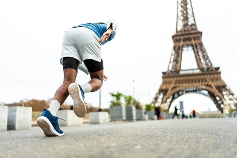 Male athlete starting to run in paris, training near the eiffel tower, symbolizing endurance,