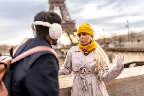 Young couple having an animated conversation outdoors, enjoying a european city break during winter