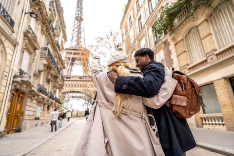 Young diverse couple embracing and enjoying a romantic trip in the streets of paris, walking