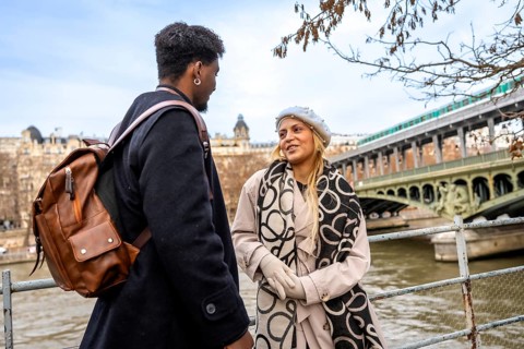 Diverse young couple chatting on bir hakeim bridge over the seine in paris, sharing a romantic