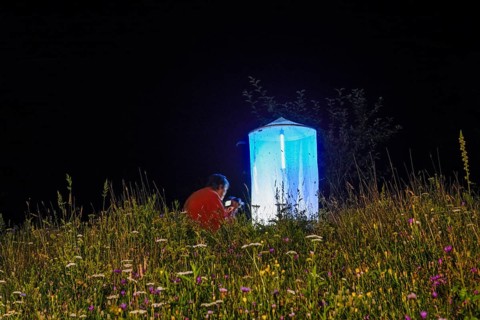 Person, biologist, butterfly researcher observing an illuminated tent Light catch full of insects