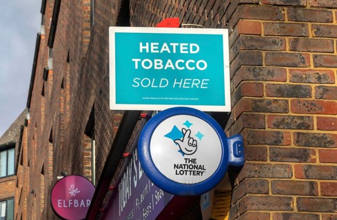 Wall mounted sign for Heated Tobacco Sold Here and The National Lottery, Reading, Berkshire,