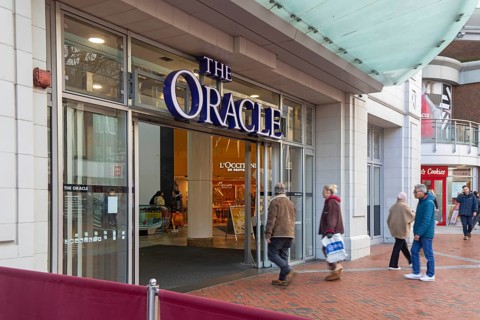 Shoppers walking into The Oracle shopping centre, town centre of Reading, Berkshire, England, UK