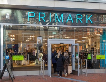 Shoppers entering through doorway entrance of Primark shop in town centre of Reading, Berkshire,