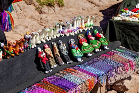 Handmade dolls and animals in traditional clothing at a souvenir market in Peru, souvenirs and