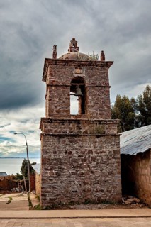 An old stone bell tower in cloudy sky surrounded by rustic landscape, The historic church on