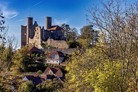 View of medieval castle above a village with autumn trees, Hanstein Castle near Bornhagen in the
