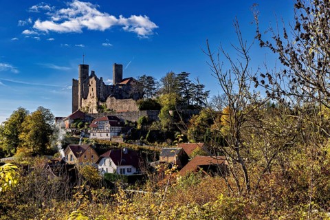 Autumn view of the village with castle on a hill under a clear sky, Hanstein Castle near Bornhagen