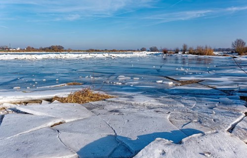 Ice on the banks of the Elbe and remnants of snow in the foothills of the Elbe on a clear winter