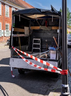Red and white barrier tape in front of the back of a pickup truck, Potsdam, Brandenburg, Germany
