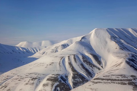The snow covered mountains Hiorthfjellet and Adventtoppen along Adventfjorden, Advent Bay in
