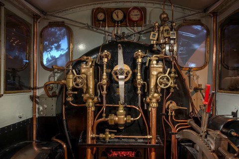 Pressure gauges and valves in steam engine cab, driver's compartment of steam locomotive at Train
