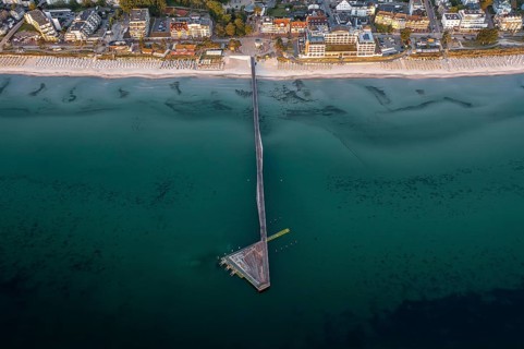 Aerial view over Seebrücke, pier and sandy beach at seaside resort Scharbeutz along the Baltic Sea,