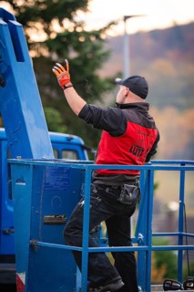 Man in red jacket standing on a blue lift, tree work, Gechingen, Calw district, Germany