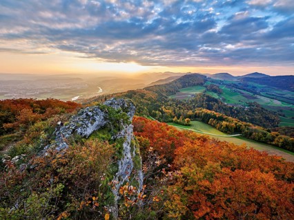 View from the Gisliflue of an autumn-colored forest, behind the Jurassic foothills with water fluh