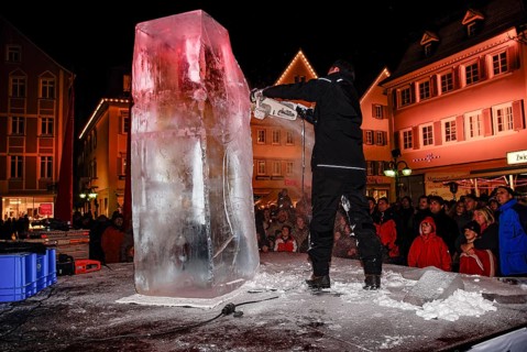 An ice sculpture is being created: ice carving street action as part of the long shopping night in
