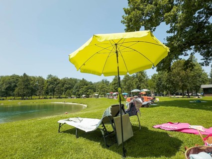 Vacation, umbrellas and sunbeds on the shores of Lake Neubeurer, Bavaria, Germany
