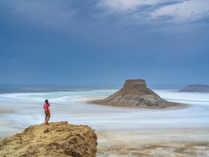 A tourist admires the inselbergs Karamaya and the Three Brothers (Three Batyrs), the Karagiye