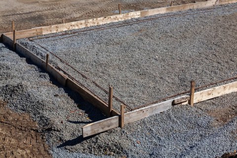 Wooden concrete pouring forms and bed of crushed and compacted stone aggregate to rest concrete