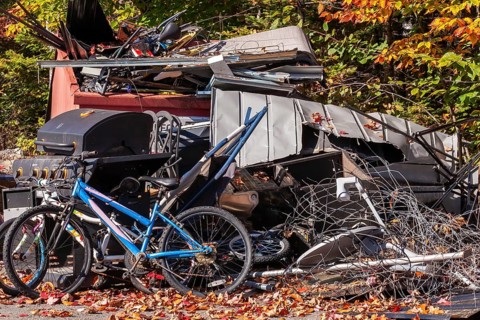 Pile of discarded metal objects including bicycles, sheet metal cladding, pipes, steel wire waiting