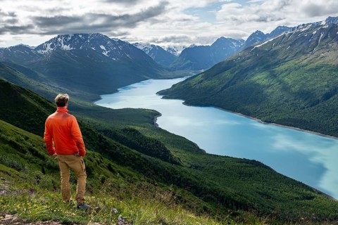 Mountaineer enjoys views of blue lake and mountains on Twin Peaks Trail, Eklutna Lake, Chugach
