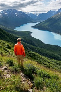 Mountaineer enjoys views of blue lake and mountains on Twin Peaks Trail, Eklutna Lake, Chugach