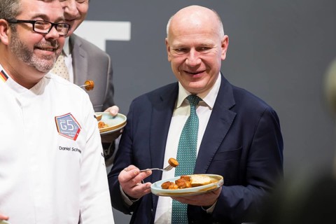 Kai Wegner (Governing Mayor of Berlin) tries a currywurst during the opening tour of the Green Week