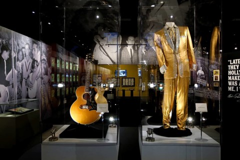 Golden clothing and an Elvis guitar on display in a museum, Memphis, Tennessee, USA